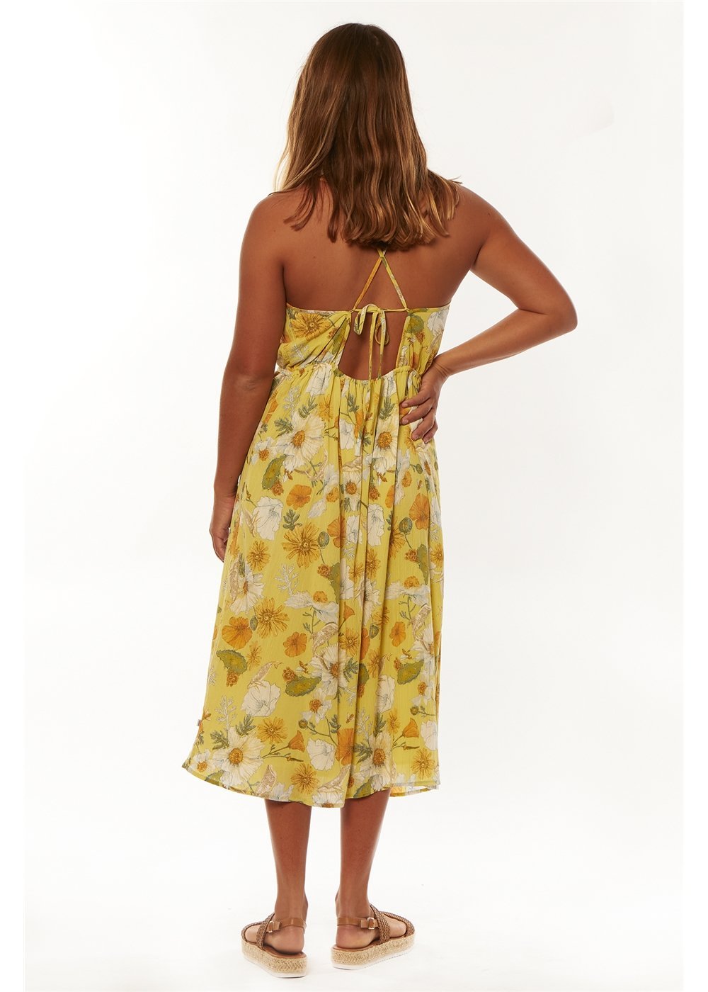 back of Woman wearing a yellow floral dress on a white background